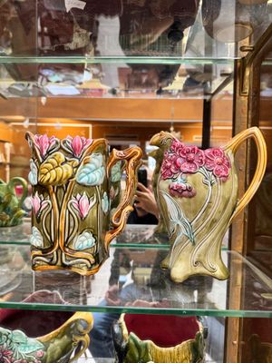 many vases that are on display in a glass case