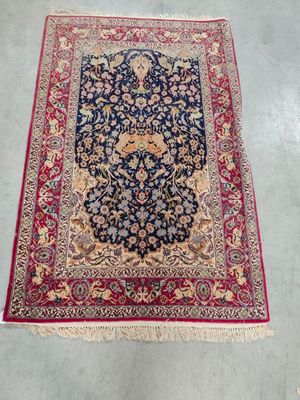 a blue rug with a red border and a floral design on it