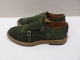 a close up of a pair of green shoes on a white surface