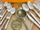 many spoons and spoon spoons and a bottle opener on a table