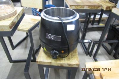 un pot noir posé sur une table en bois dans une pièce