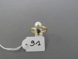 une photo d'une bague ornée d'une perle
