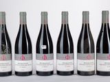 six bouteilles de vin sont alignées sur une table