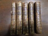 Quatre vieux livres sont alignés sur une table en bois