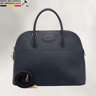 un sac à main en cuir noir avec des finitions dorées et une bandoulière