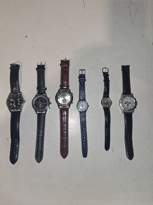plusieurs montres différentes sont alignées sur une surface blanche