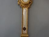 a gold clock hanging on the wall in a room