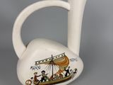 a white vase with a picture of a boat on it