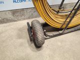 a wheel with a hose attached to it on the ground