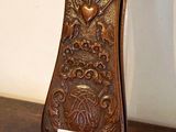 une petite horloge en bois posée sur un socle, sur une table