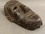 un masque en bois posé sur une table