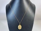 un collier en or avec une pièce de monnaie sur le cou d'un mannequin