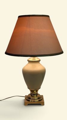 une lampe posée sur une table, avec un abat-jour marron