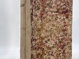 an old book sitting on top of a white surface