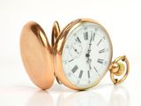 a gold pocket watch with roman numerals on it