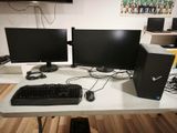 two computer monitors and a keyboard on a desk