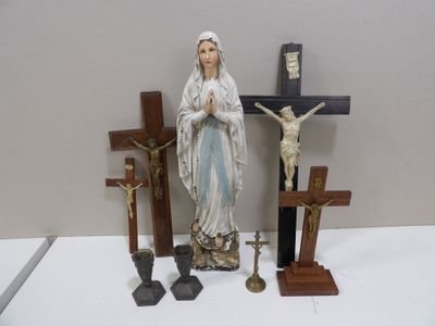 une statue représentant une femme tenant une croix, à côté d'un crucifix