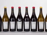 six bottles of wine are lined up in a row on a table