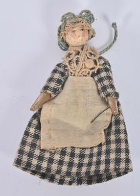 an old fashioned doll with a plaid dress and a hat