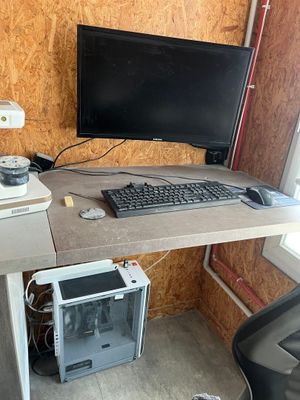 a computer desk with a monitor, keyboard and mouse on it