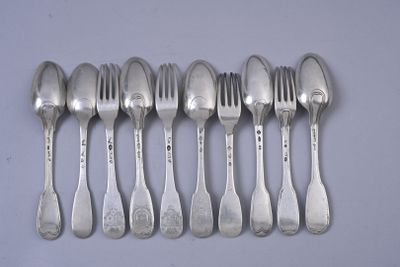 six spoons and a fork are lined up on a table