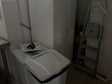 an image of a kitchen with a trash can and a refrigerator