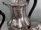 a silver tea pot and a silver teapot on a table
