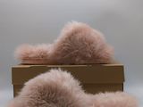 pair of pink furry slippers sitting on top of a cardboard box