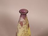 a purple and yellow vase sitting on top of a table