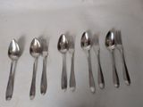 six spoons and six spoons sitting on a table
