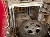 une table sur laquelle est posé un saladier, à côté d'un tas de pneus