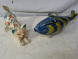 deux figurines représentant un chat et un poisson posées sur une table