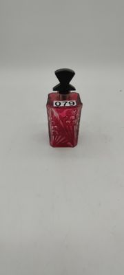 an image of a small bottle of perfume on a white surface