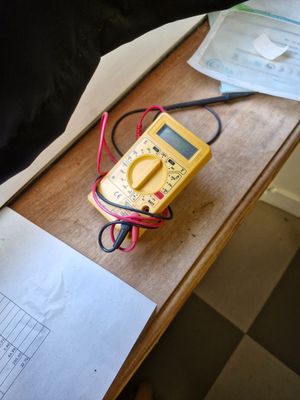 a dog that is sitting on a table with a multimeter