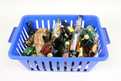 a blue basket full of beer bottles on a white table