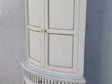 une grande armoire blanche surmontée d'une porte