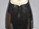 bottle of red wine with a red cap on a grey background