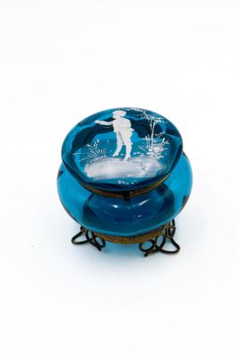 un bol en verre bleu sur lequel est représenté un homme