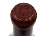 a close up of a bottle of wine on a white surface