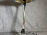 une photo d'une lampe de table avec un pied argenté et un cordon noir