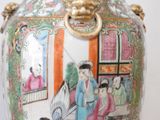 a vase with a painting on it sitting on a table
