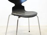 an image of a black chair against a white wall