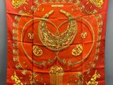 a red and gold silk scarf with a bird on it