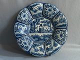 blue and white plate with oriental design on it on a white surface