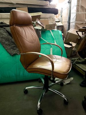 a brown leather office chair in a room full of boxes