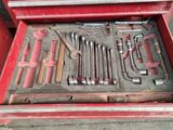 a red tool box with tools in it on the ground