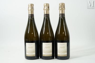 trois bouteilles de vin posées les unes à côté des autres sur une surface blanche