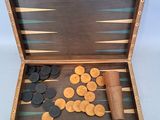 an image of a wooden backgamrd with coins and a roll of paper