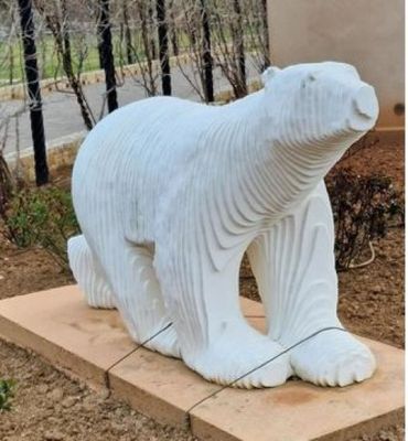 a statue of a polar bear sitting on a stone block