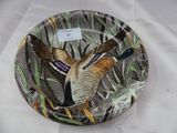 une assiette sur laquelle est peint un oiseau, posée sur une table